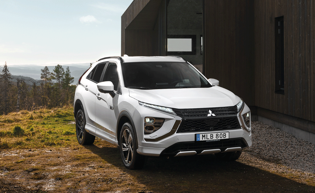 Mitsubishi Eclipse Cross Plug-in Hybrid, parkerad framför stuga i skogsmiljö