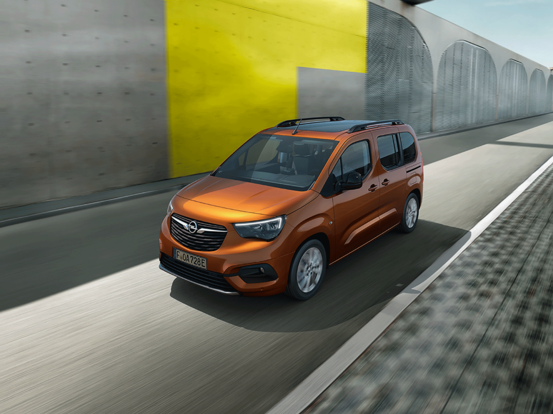 Opel Combo-e Life, kör längs med en grå och gul vägg