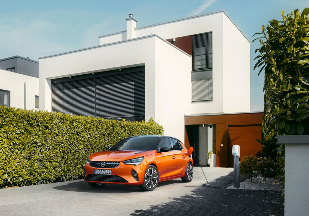 Opel Corsa-e, parkerad på uppfart och laddas via laddstolpe